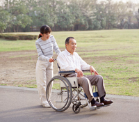 車椅子の男性と車椅子を押している女性